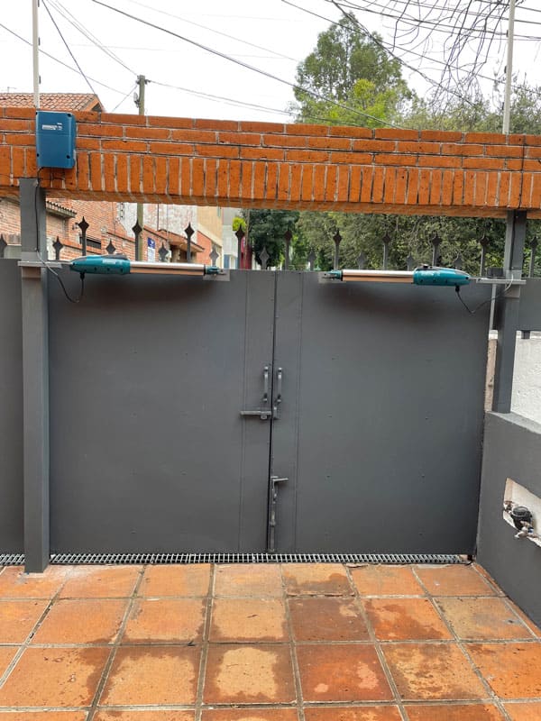Pistón merik instalado en portón abatible para apertura sin bajar del auto