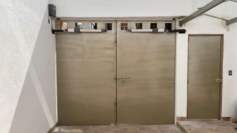 Portón abatible al que se le instalo un pistón para apertura automática