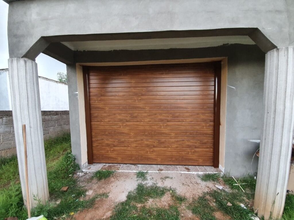Instalación profesional de puerta seccional en construcción de casa residencial